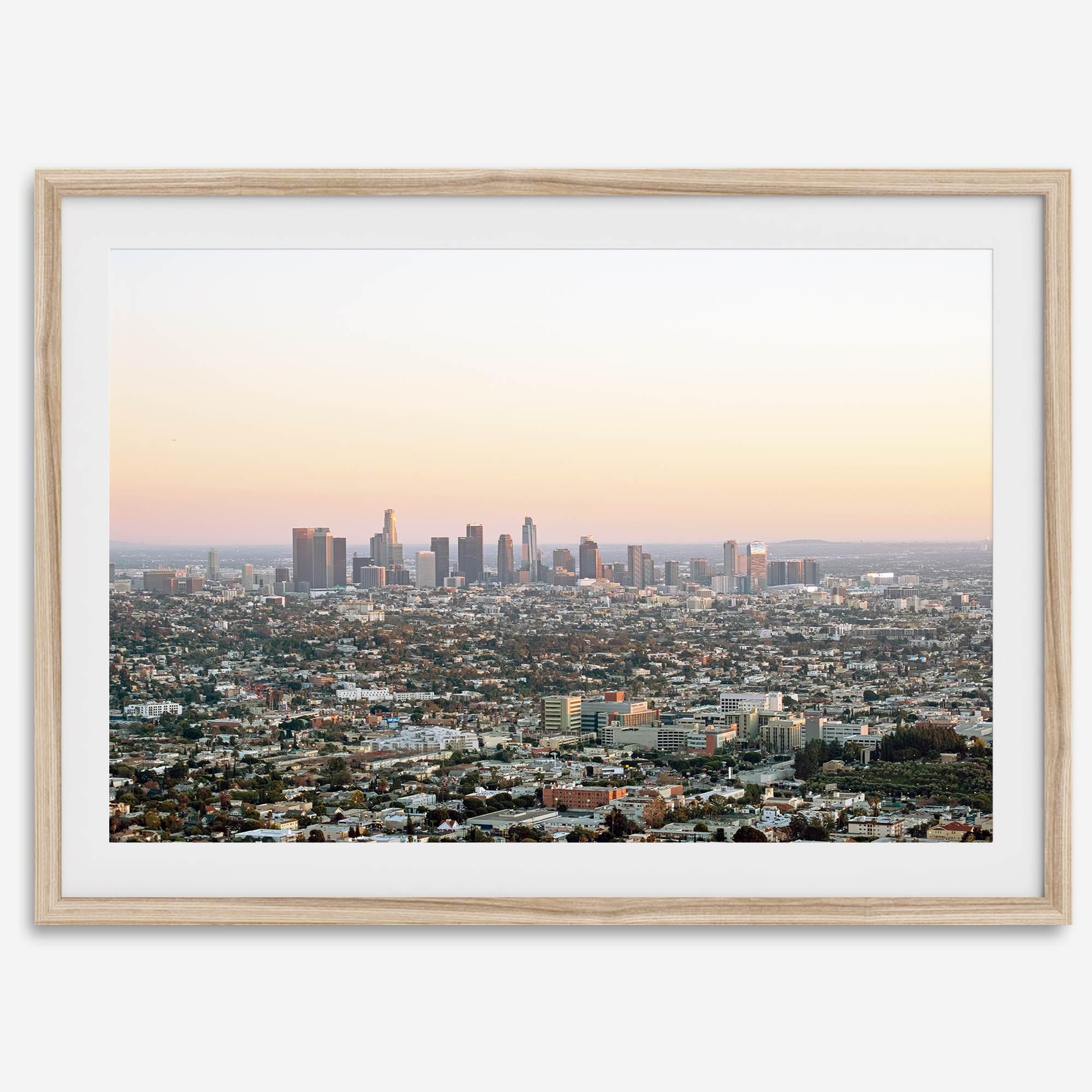 Los Angeles cityscape bathed in a vibrant sunset, showcasing the city's iconic buildings from above