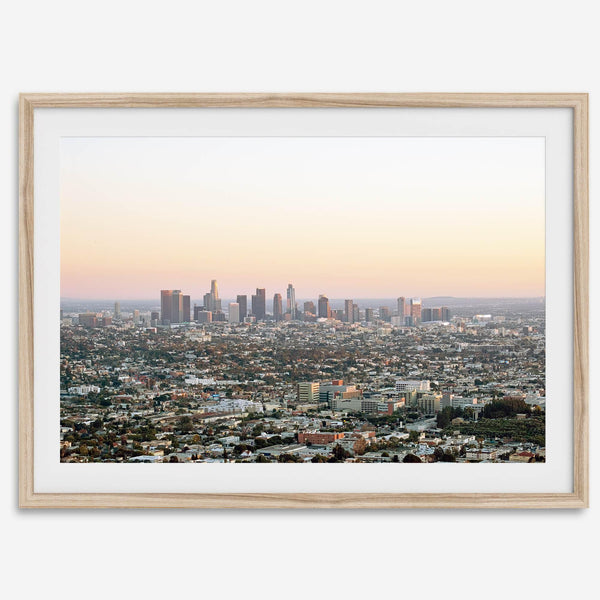 Los Angeles cityscape bathed in a vibrant sunset, showcasing the city's iconic buildings from above