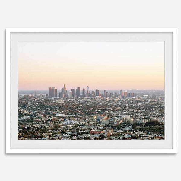Los Angeles cityscape bathed in a vibrant sunset, showcasing the city's iconic buildings from above