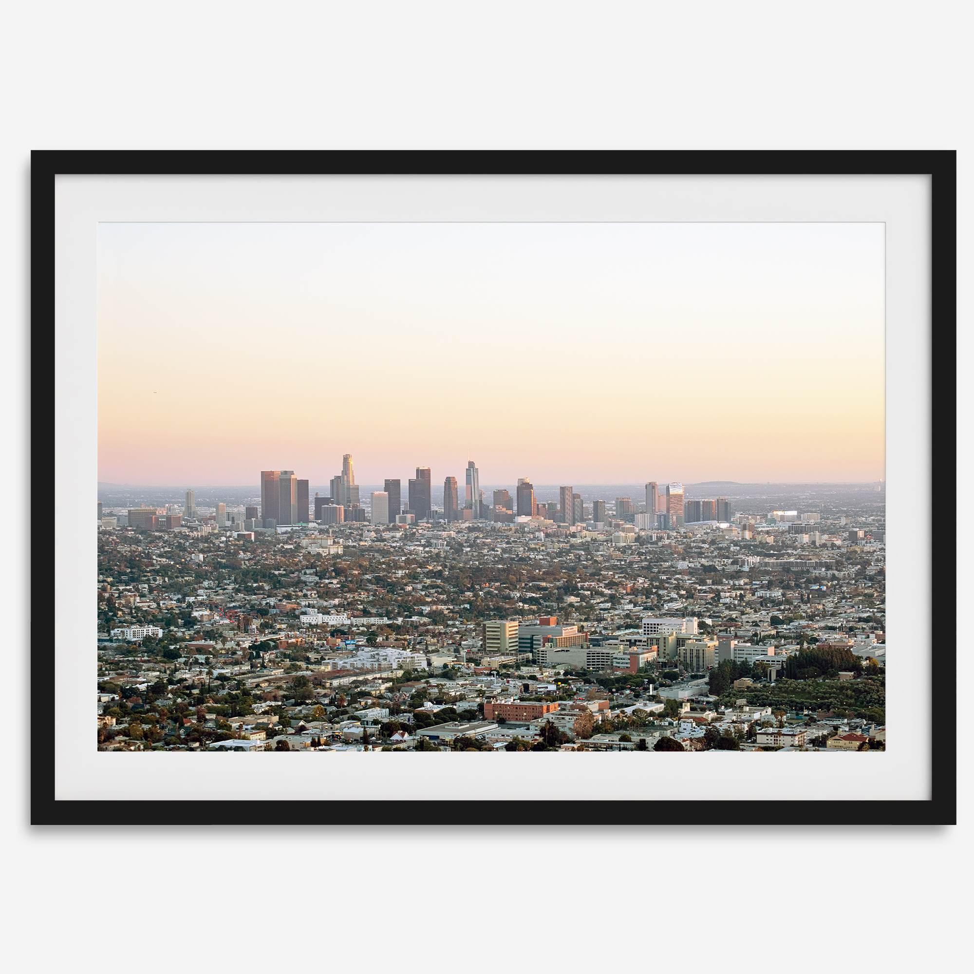 Los Angeles cityscape bathed in a vibrant sunset, showcasing the city's iconic buildings from above