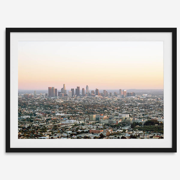 Los Angeles cityscape bathed in a vibrant sunset, showcasing the city's iconic buildings from above