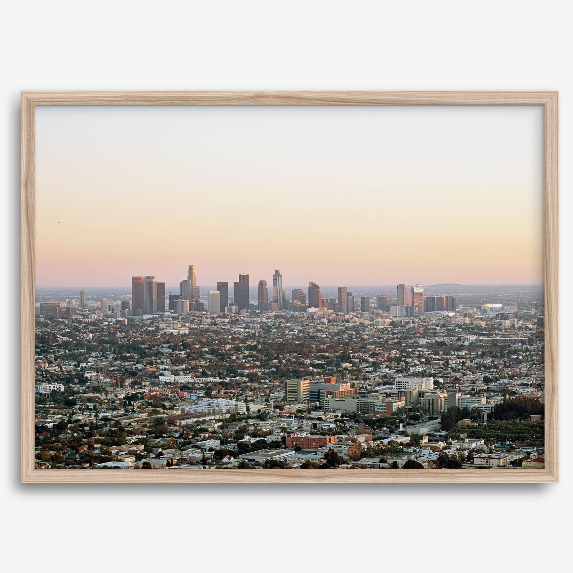 Los Angeles cityscape bathed in a vibrant sunset, showcasing the city's iconic buildings from above