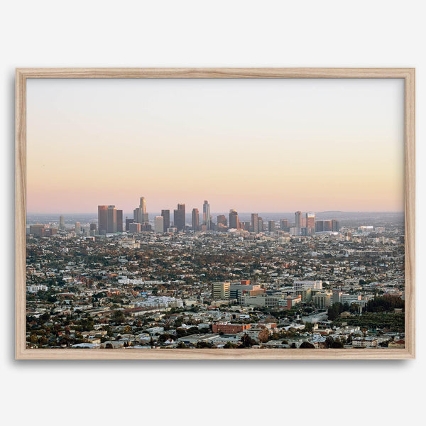 Los Angeles cityscape bathed in a vibrant sunset, showcasing the city's iconic buildings from above