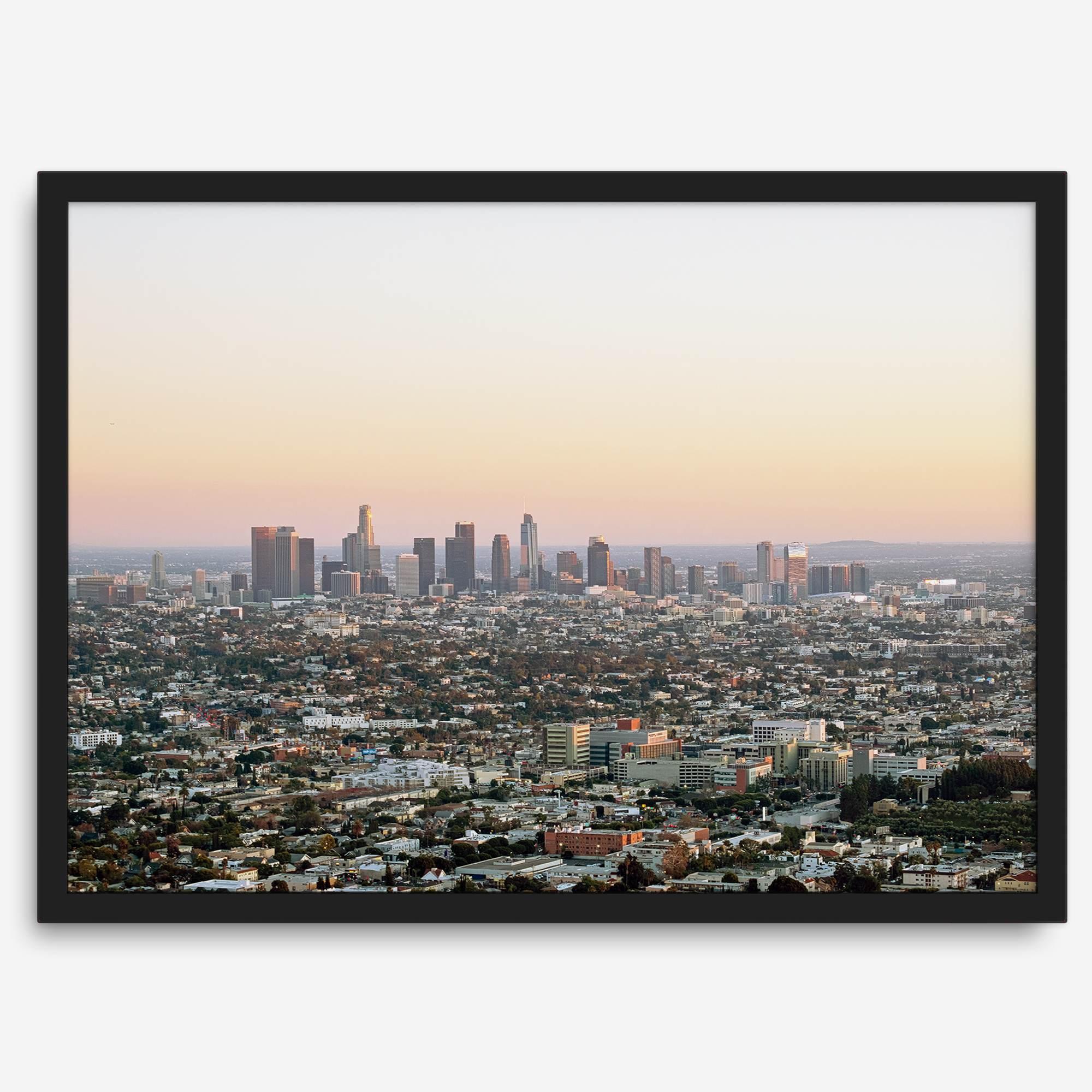 Los Angeles cityscape bathed in a vibrant sunset, showcasing the city's iconic buildings from above
