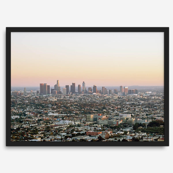 Los Angeles cityscape bathed in a vibrant sunset, showcasing the city's iconic buildings from above
