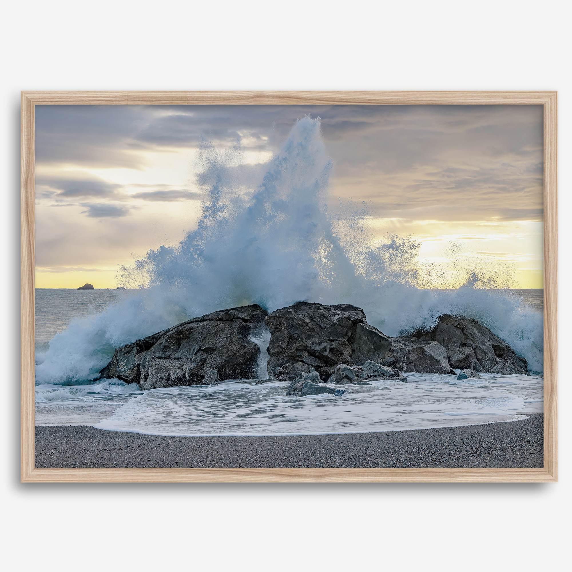 A dramatic fine art beach print showing a huge ocean wave crashing on a beautiful beach in California during sunset