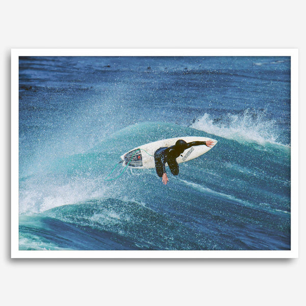 Surfer flying above a turquoise wave in Santa Cruz captured in vibrant ocean photography.