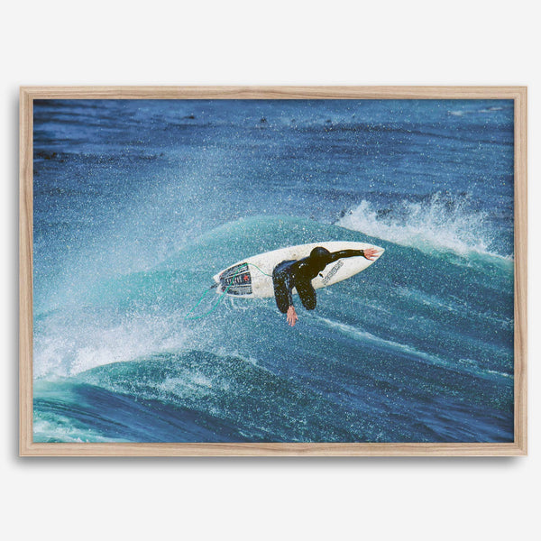 Surfer flying above a turquoise wave in Santa Cruz captured in vibrant ocean photography.