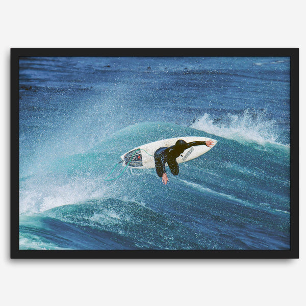 Surfer flying above a turquoise wave in Santa Cruz captured in vibrant ocean photography.