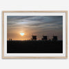 Step into Venice Beach with our fine art beach sunset framed or unframed print. The print showcases the beach in sunset with the silhouettes of the famous lifeguard towers and people in the sunset.