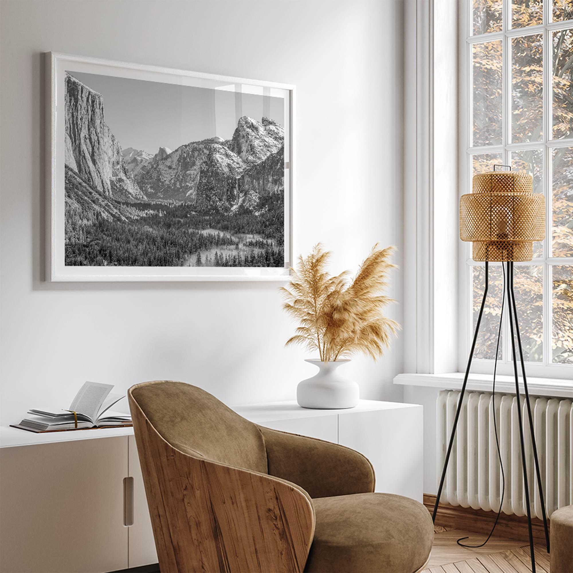 A fine art Yosemite Print featuring Yosemite Valley covered in snow in winter and a beautiful fog lays in the valley forest. This black and white mountain wall art is perfect for nature and fine art lovers.