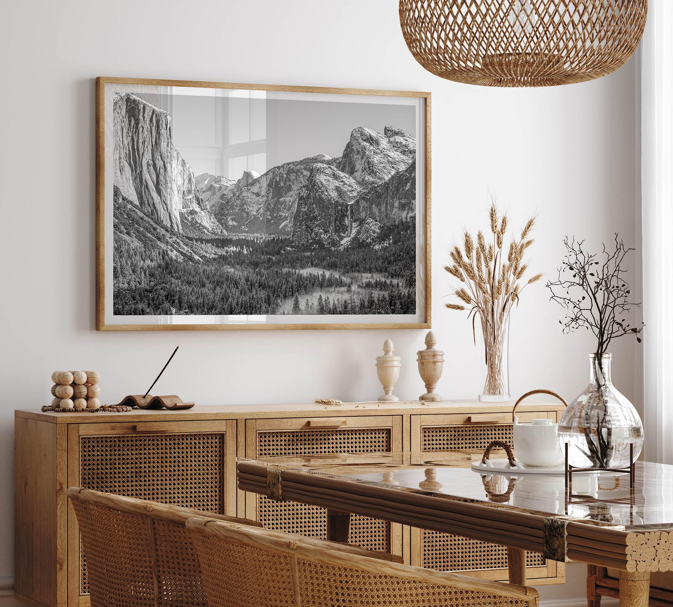 A fine art Yosemite Print featuring Yosemite Valley covered in snow in winter and a beautiful fog lays in the valley forest. This black and white mountain wall art is perfect for nature and fine art lovers.