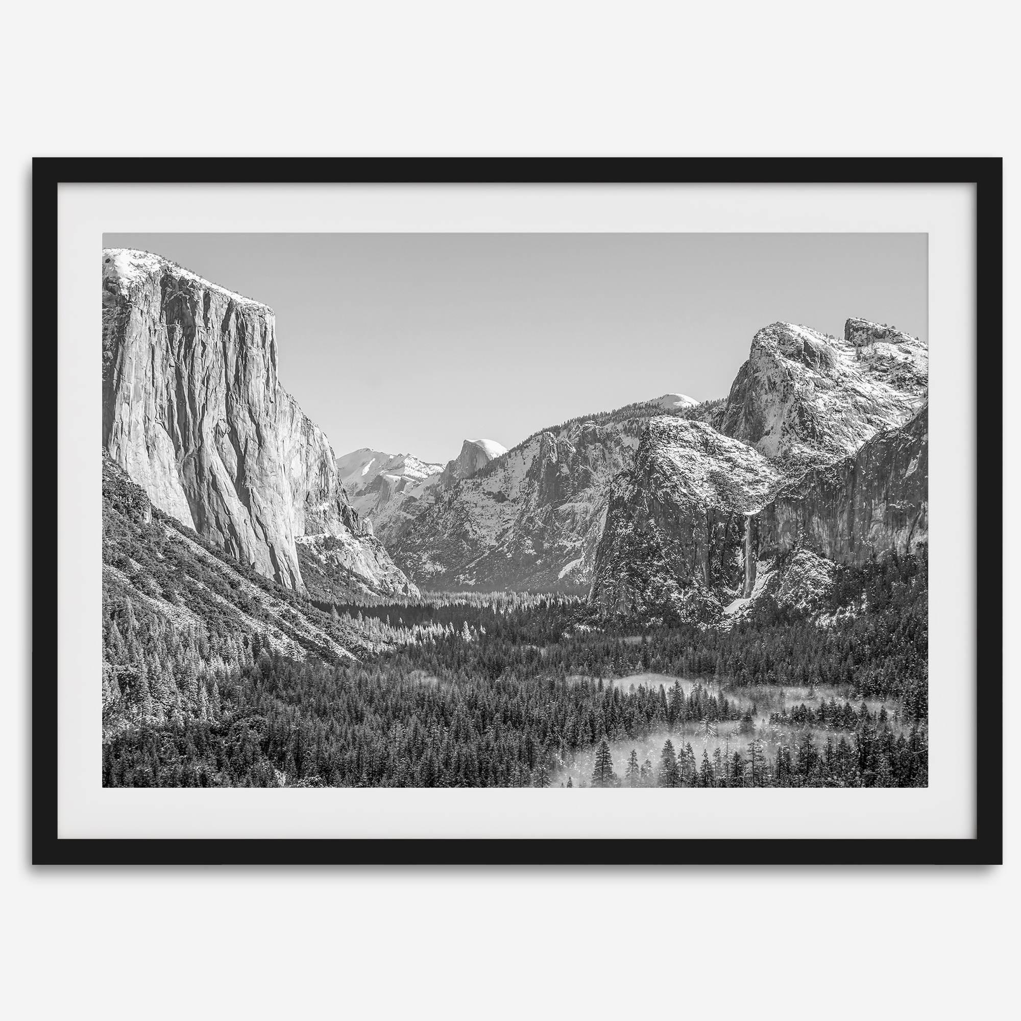 A fine art Yosemite Print featuring Yosemite Valley covered in snow in winter and a beautiful fog lays in the valley forest. This black and white mountain wall art is perfect for nature and fine art lovers.