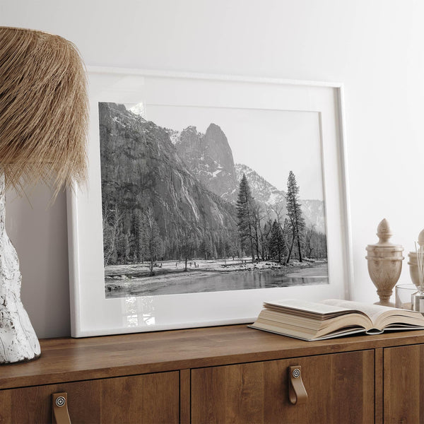 Black and white fine art print of Yosemite National Park in winter with snow-covered trees and granite cliffs.