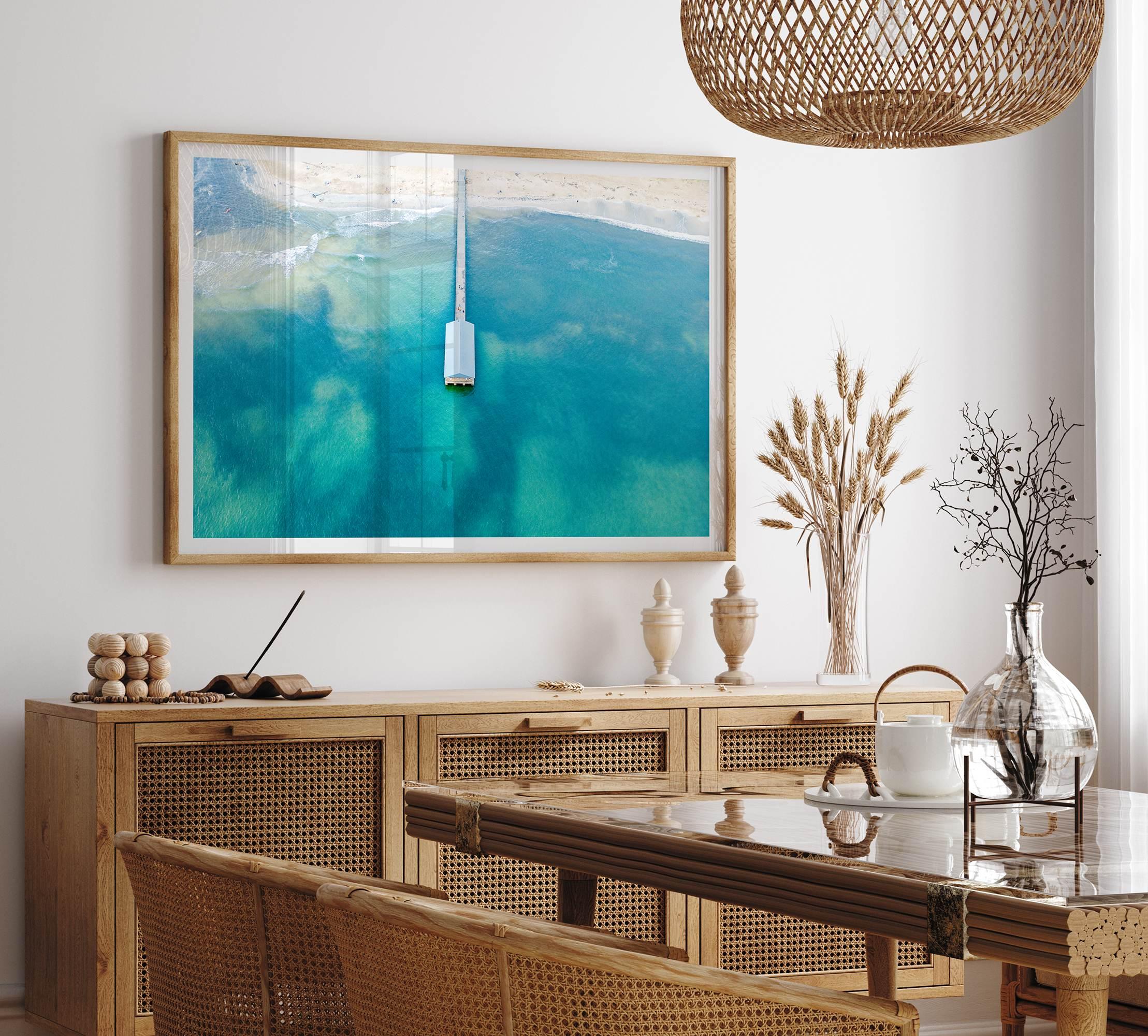 Drone photo of a pier extending into clear blue ocean at Hanalei Beach, Kauai, Hawaii.