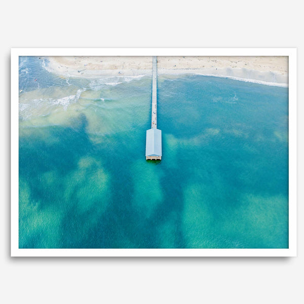 Drone photo of a pier extending into clear blue ocean at Hanalei Beach, Kauai, Hawaii.