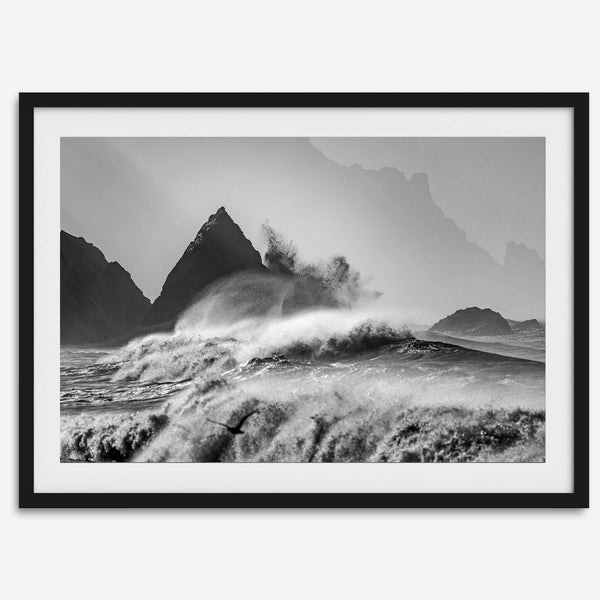 Black and white crashing waves wall art with dramatic ocean spray, jagged cliffs, and a moody atmosphere.