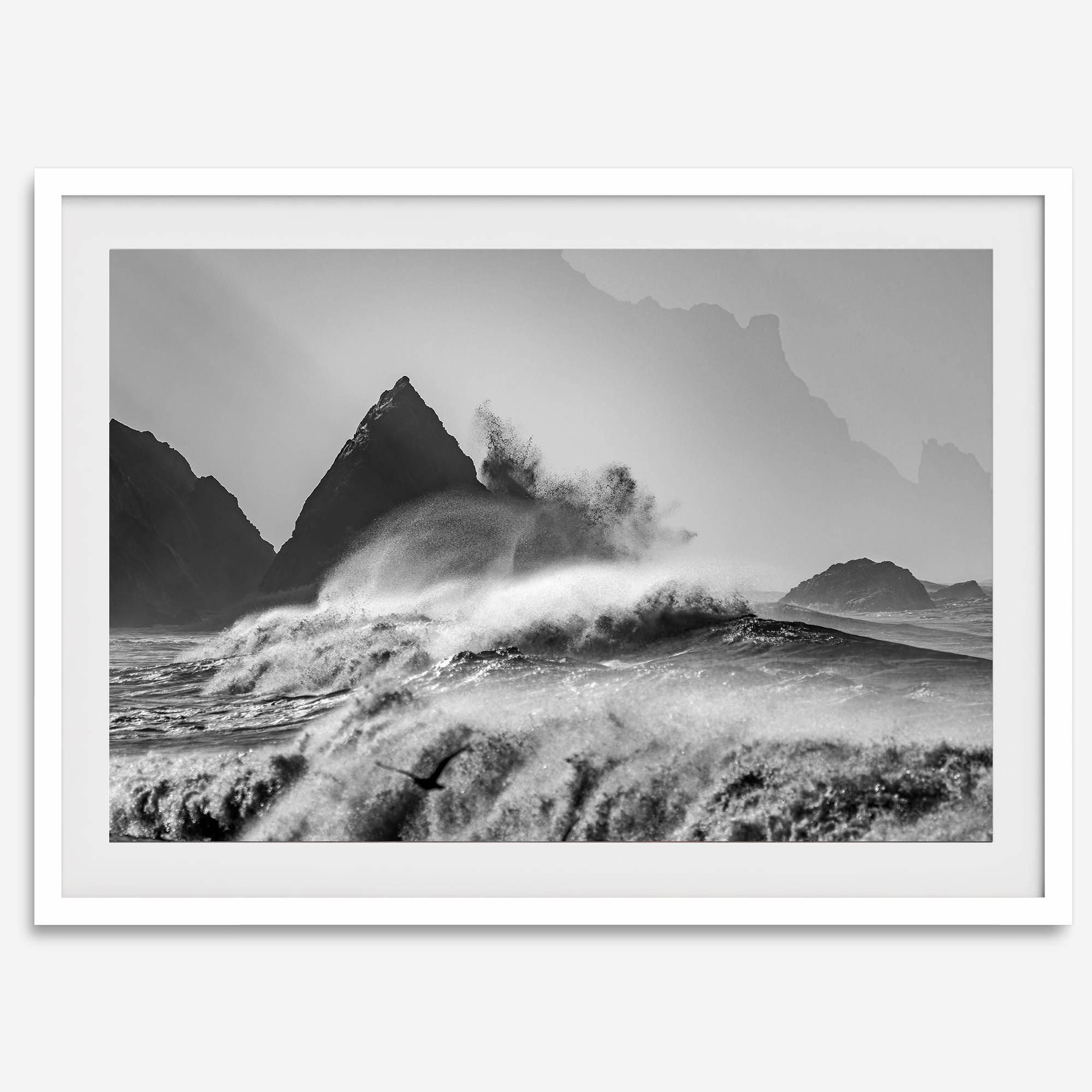 Black and white crashing waves wall art with dramatic ocean spray, jagged cliffs, and a moody atmosphere.