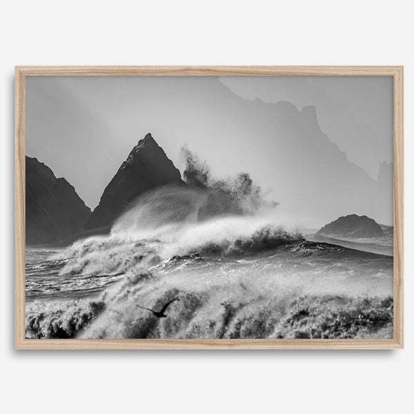 Black and white crashing waves wall art with dramatic ocean spray, jagged cliffs, and a moody atmosphere.