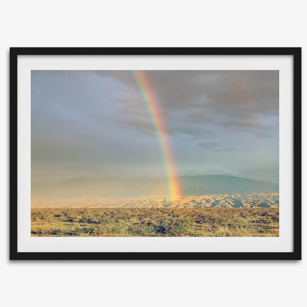 Desert landscape artwork of a rainbow over Arizona sand dunes with distant mountains.