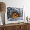 A fine art mountain photography print showing a Yosemite National Park winter scene: A mysterious snow-covered tunnel with an orange glow beckons visitors deeper into the park.