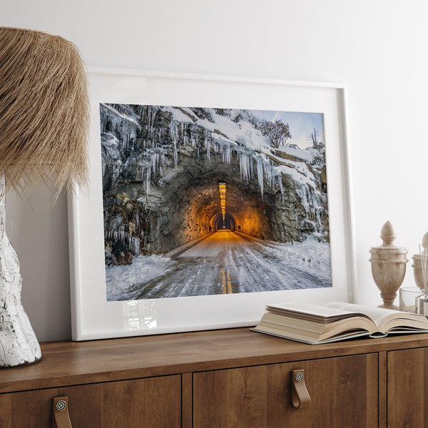 A fine art mountain photography print showing a Yosemite National Park winter scene: A mysterious snow-covered tunnel with an orange glow beckons visitors deeper into the park.