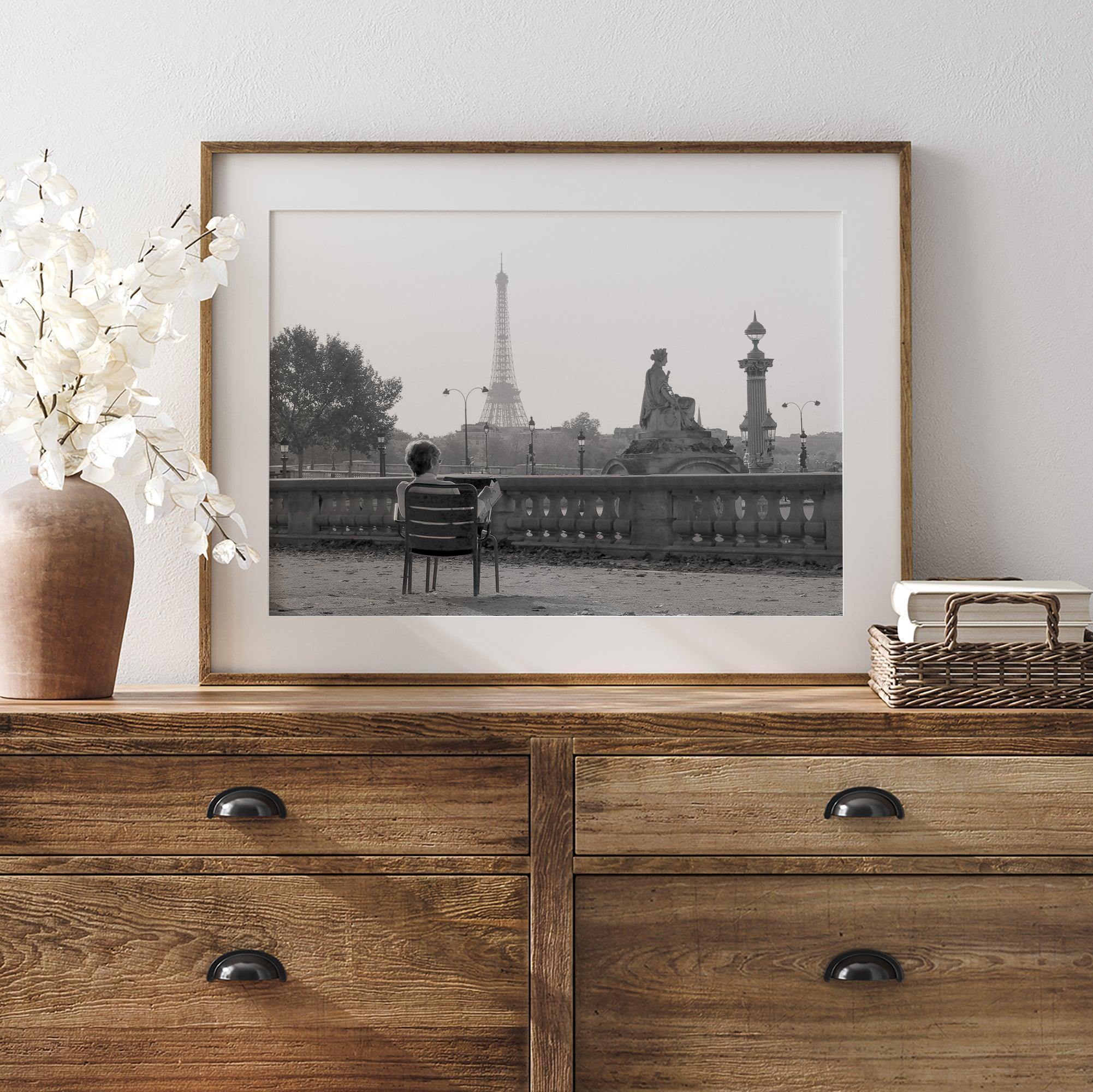 Black-and-white Paris wall art featuring a woman reading in a park with the Eiffel Tower in the background.
