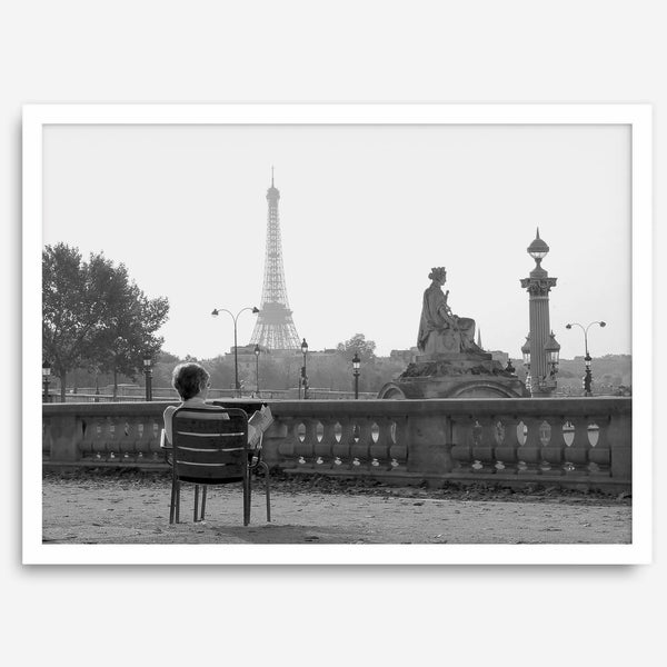 Black-and-white Paris wall art featuring a woman reading in a park with the Eiffel Tower in the background.