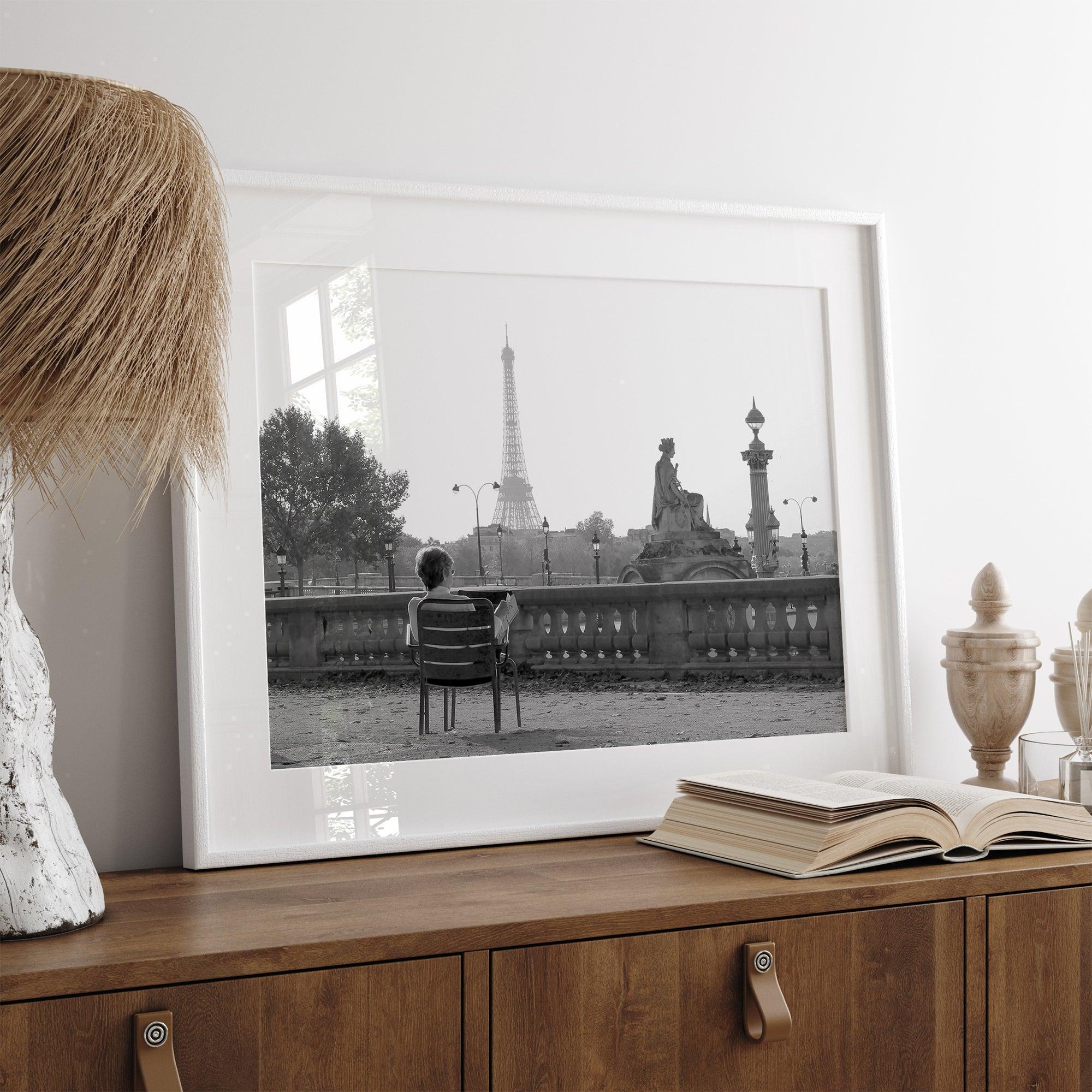 Black-and-white Paris wall art featuring a woman reading in a park with the Eiffel Tower in the background.