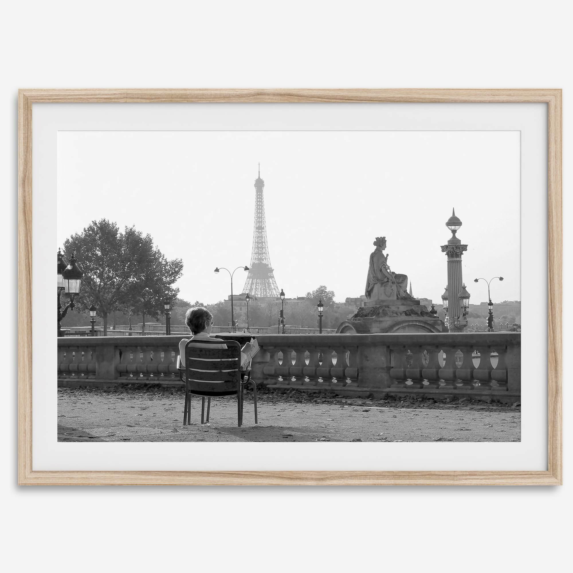 Black-and-white Paris wall art featuring a woman reading in a park with the Eiffel Tower in the background.