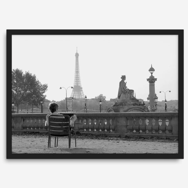 Black-and-white Paris wall art featuring a woman reading in a park with the Eiffel Tower in the background.