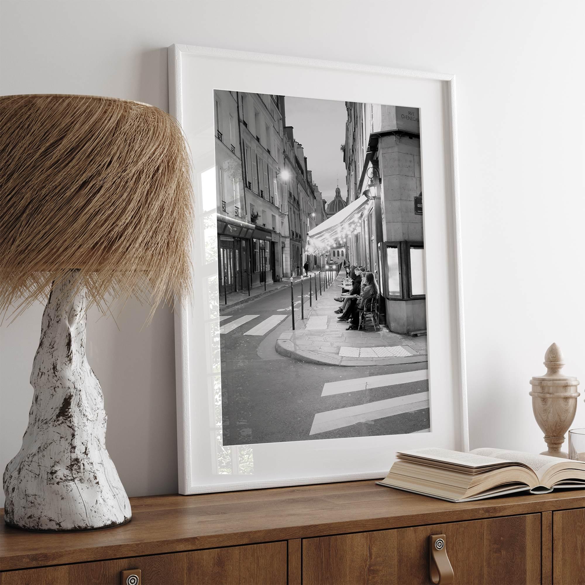 Paris street photography showing glowing café at dusk on Rue de l’Université in black and white.