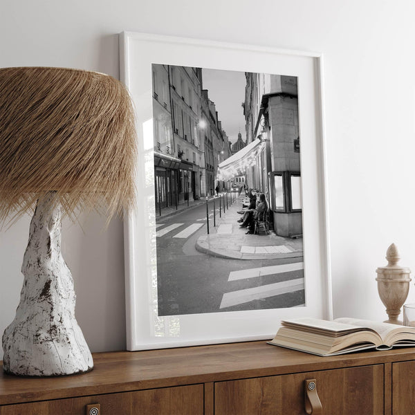 Paris street photography showing glowing café at dusk on Rue de l’Université in black and white.