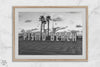 Black and white photo of the Pismo Beach street sign with palm trees and boardwalk – fine art coastal print