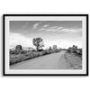 A fine black and white desert print, featuring Monument Valley in the Utah/ Arizona desert. The print shows a road that goes through the towering rocks and unique trees of monument valley.