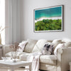 A fine art beach print from above with emerald colors and lush forest.