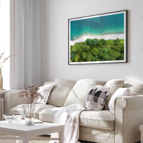 A fine art beach print from above with emerald colors and lush forest.