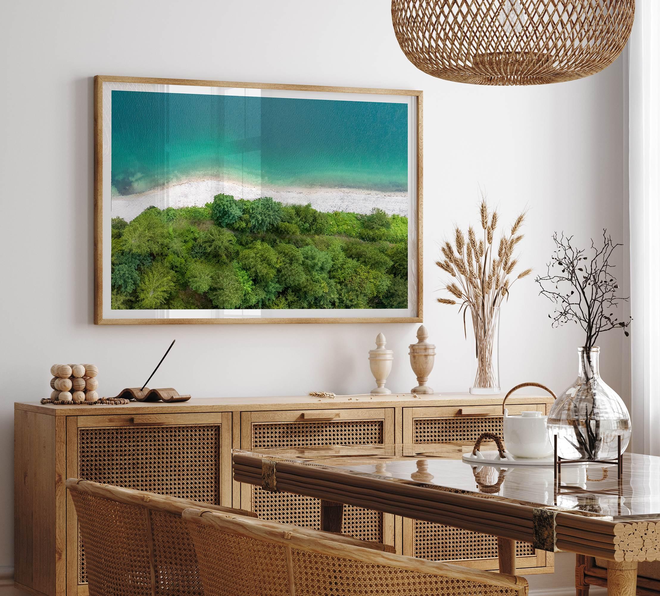 A fine art beach print from above with emerald colors and lush forest.