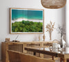 A fine art beach print from above with emerald colors and lush forest.