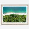 A fine art beach print from above with emerald colors and lush forest.