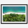 A fine art beach print from above with emerald colors and lush forest.