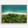 A fine art beach print from above with emerald colors and lush forest.