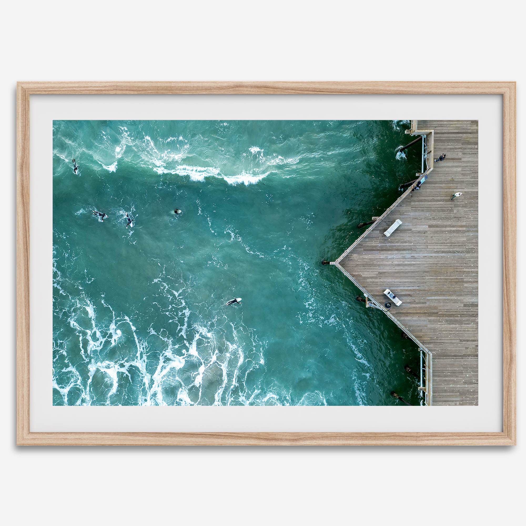 Aerial photo of Pismo Pier with surfers and turquoise ocean waves, ideal for coastal wall decor.