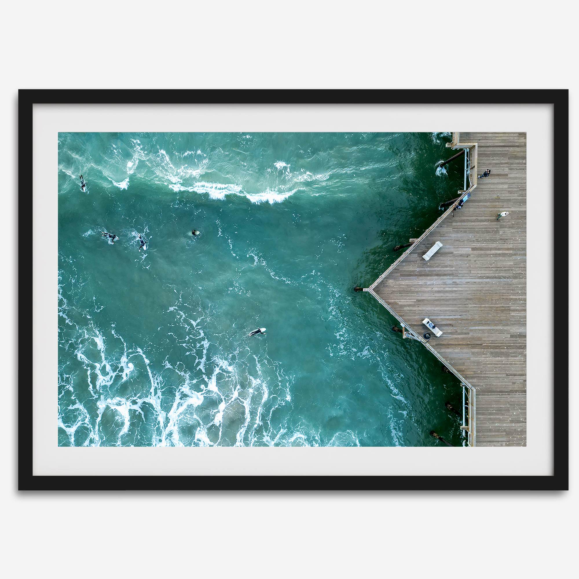 Aerial photo of Pismo Pier with surfers and turquoise ocean waves, ideal for coastal wall decor.