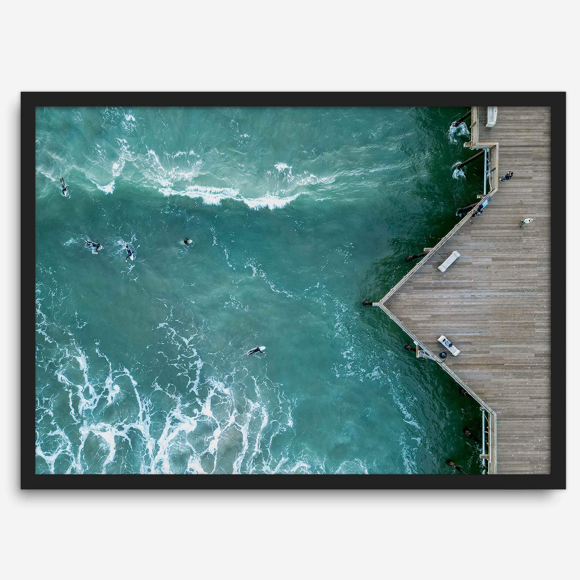 Aerial photo of Pismo Pier with surfers and turquoise ocean waves, ideal for coastal wall decor.