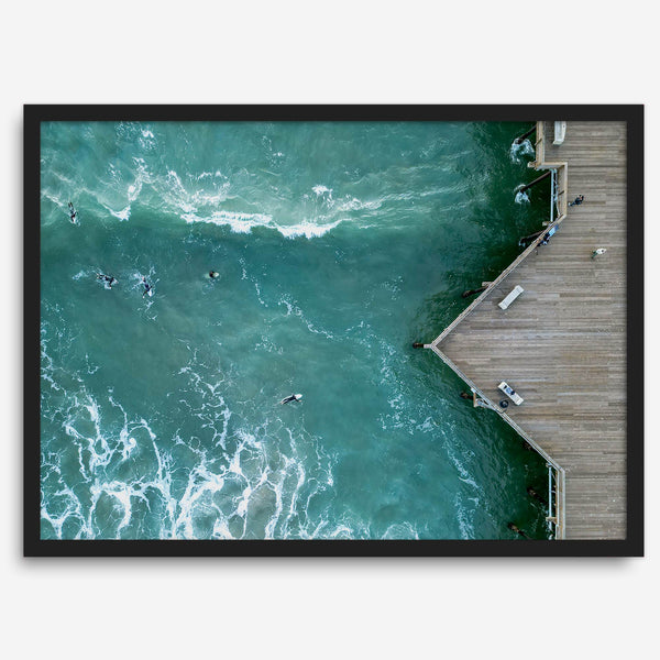 Aerial photo of Pismo Pier with surfers and turquoise ocean waves, ideal for coastal wall decor.
