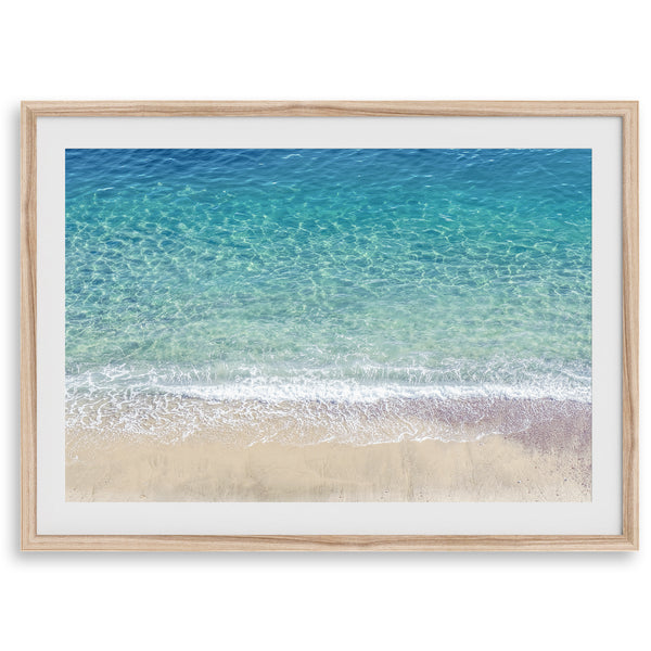 This fine art aerial beach print showcases the mesmerizing colors of the ocean in vivid detail. From the deep blue depths to the vibrant greenish turquoise blue, transitioning to the golden sandy beach and the crashing white surf.