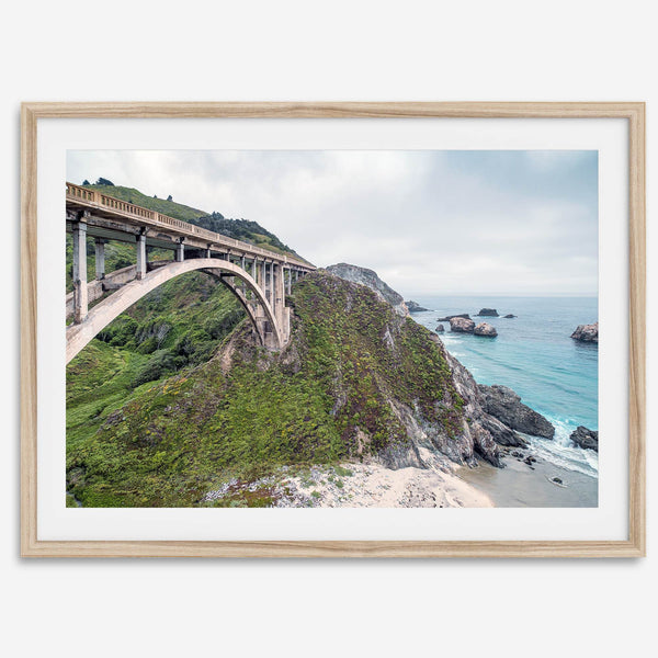 A fine art ocean print of one of the most iconic spots in the famous Route 1 in California - Bixby Bridge near Big Sur. Shot in a unique wide angle that captures the bridge, cliffs, the ocean, and the stunning beach below.