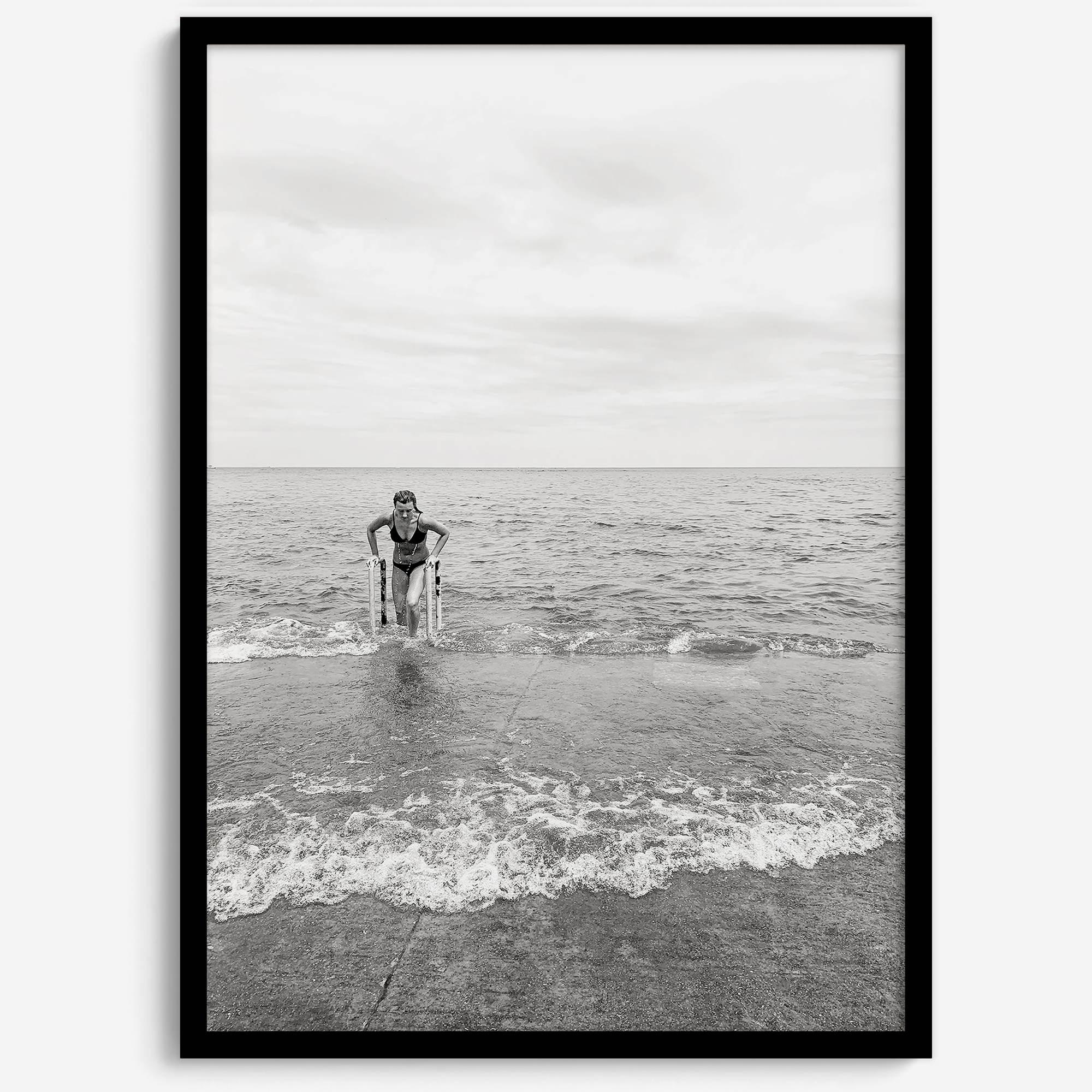 A black and white fine art lake beach print of a beach in Chicago on the coast of Lake Michigan showcasing a woman bathing in the lake. The classic modern look of the print is sure to impress when hung on your walls.