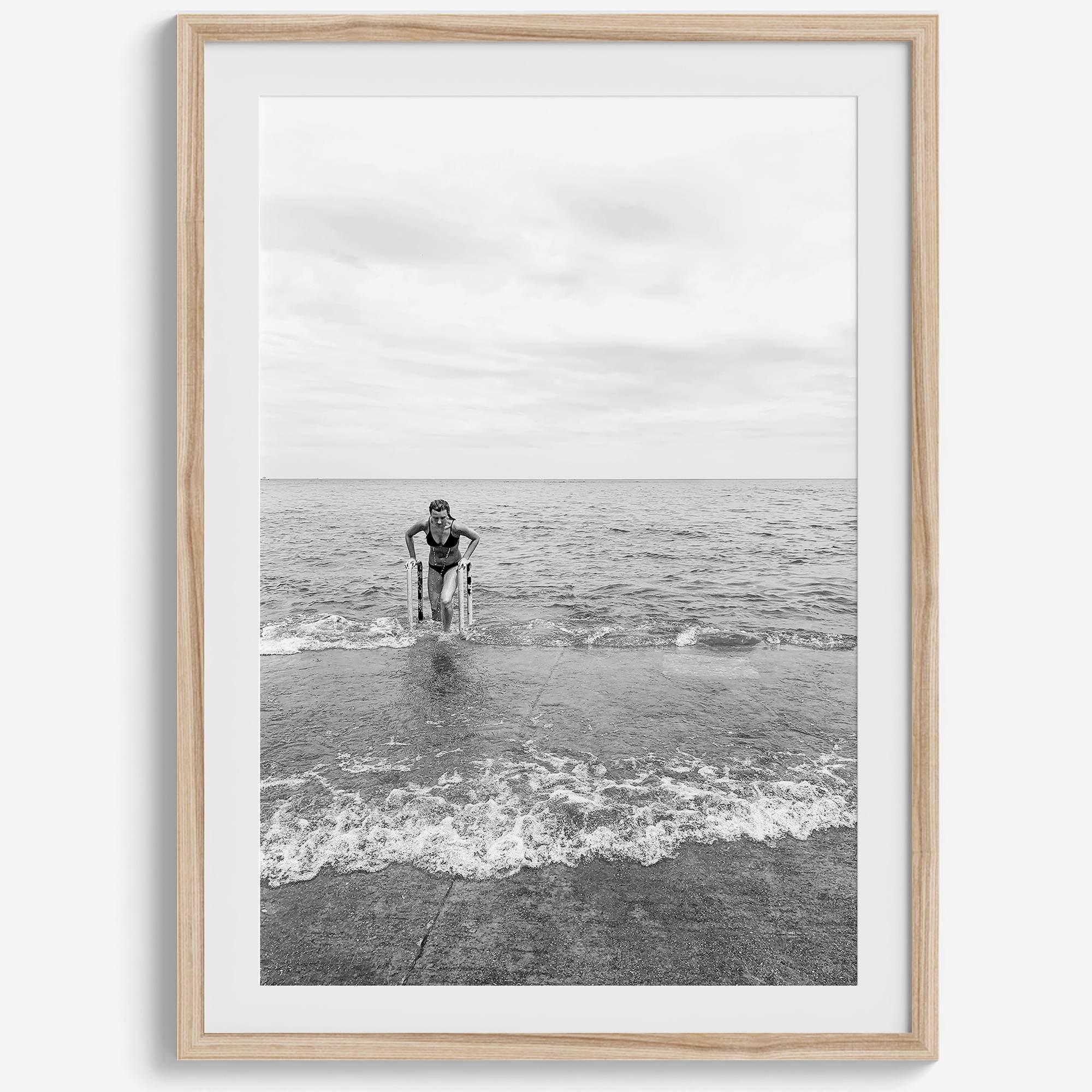 A black and white fine art lake beach print of a beach in Chicago on the coast of Lake Michigan showcasing a woman bathing in the lake. The classic modern look of the print is sure to impress when hung on your walls.